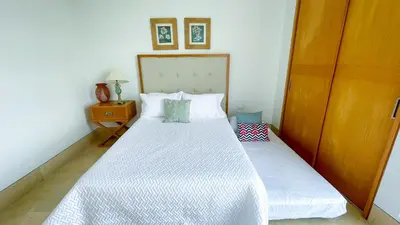 a bedroom with a white bed with a wooden door at Magico Apartamento Frente al Mar 3 Habitaciones TR72 in Coveñas