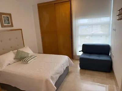a bedroom with a bed and a blue chair at Magico Apartamento Frente al Mar 3 Habitaciones TR72 in Coveñas