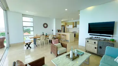 a living room with a couch and a tv and a table at Magico Apartamento Frente al Mar 3 Habitaciones TR72 in Coveñas
