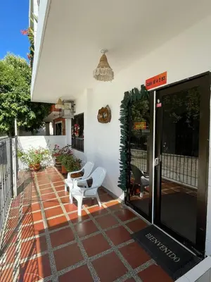 a patio with two white chairs on a house at Casa Inés Tolú in Tolú