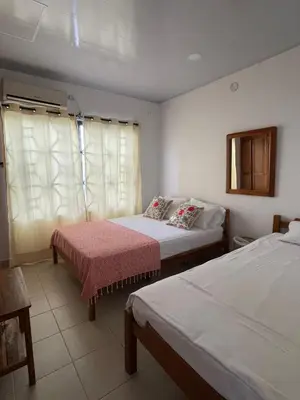a hotel room with two beds and a window at Casa Inés Tolú in Tolú