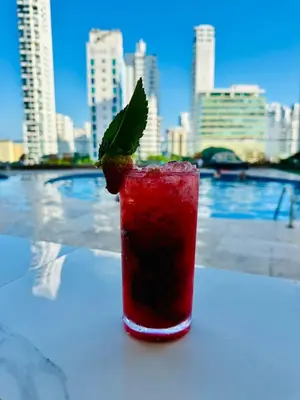 a red drink with a green leaf sitting on a table at Lodging Apto 37 Palmetto Eliptic in Cartagena de Indias