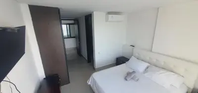 a bedroom with a white bed with white pillows at Lodging Apto 37 Palmetto Eliptic in Cartagena de Indias