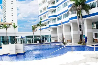 a hotel with a swimming pool in front of a building at Lodging Palmetto apto 4 Bocagrande in Cartagena de Indias