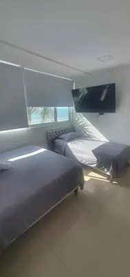 a bedroom with two beds and a window at Lodging Palmetto apto 4 Bocagrande in Cartagena de Indias