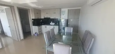 a kitchen with a glass table with chairs and a refrigerator at Lodging Palmetto apto 4 Bocagrande in Cartagena de Indias