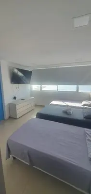 a bedroom with a bed and a large window at Lodging Palmetto apto 4 Bocagrande in Cartagena de Indias