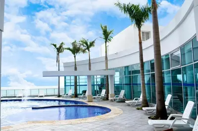 a view of a building with palm trees and a swimming pool at Lodging Palmetto apto 4 Bocagrande in Cartagena de Indias