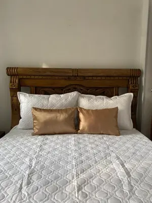 a bed with a wooden headboard and two pillows at Acogedor apartamento excelente ubicación in Barranquilla