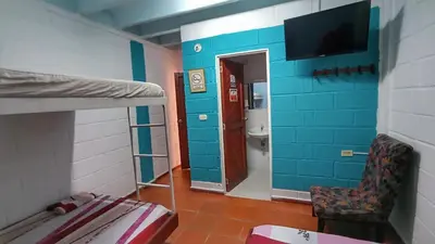 a room with a bunk bed and a room with a tv at Monkey man, Beach House in Santa Marta