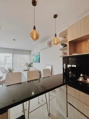 a kitchen and living room with a table and chairs at Apartamento con hermosa vista en Bocagrande in Cartagena de Indias
