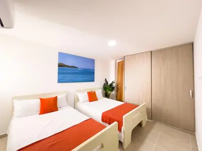 a bedroom with two beds and a cabinet at 3 Cuartos 2 balcones in Cartagena de Indias