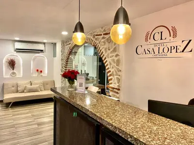 a lobby with a counter and a living room at Hotel Casa Lopez - Cartagena in Cartagena de Indias
