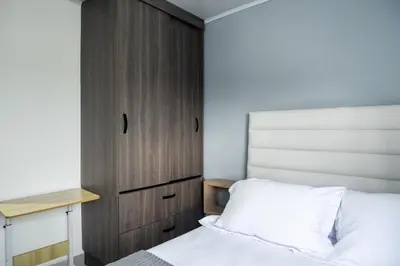 a bedroom with a bed and a wooden cabinet at Torre 811 By Jalo in Cartagena de Indias
