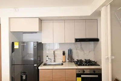 a kitchen with white cabinets and a stainless steel refrigerator at Torre 811 By Jalo in Cartagena de Indias