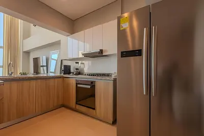 a large kitchen with a stainless steel refrigerator at Doble altura y lujoso apto vista al mar in Cartagena de Indias