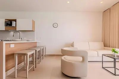 a kitchen and living room with a couch and a table at Espectacular vista a laguna de Kristal / 1 alcoba in Los Arrayanes