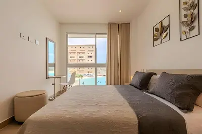 a bedroom with a large bed and a window at Espectacular vista a laguna de Kristal / 1 alcoba in Los Arrayanes