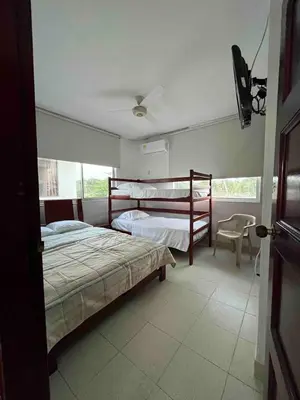 a bedroom with two bunk beds and a chair at Cabaña 5 - Conjunto frente al mar con piscina in Coveñas
