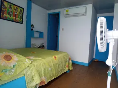 a room with a bed in a room with a fan at Renacer ancestral Barú in Playa Blanca