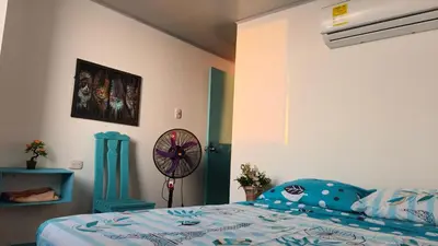 a bedroom with a bed and a fan at Renacer ancestral Barú in Playa Blanca