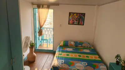 a bedroom with a bed in a room with a window at Renacer ancestral Barú in Playa Blanca