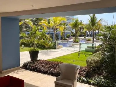 a room with a view of a courtyard with palm trees at The Beaches-Beachfront Retreat in Cartagena de Indias