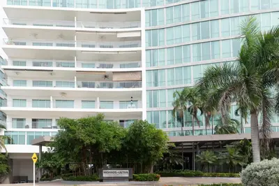 an office building with palm trees in front of it at The Beaches-Beachfront Retreat in Cartagena de Indias