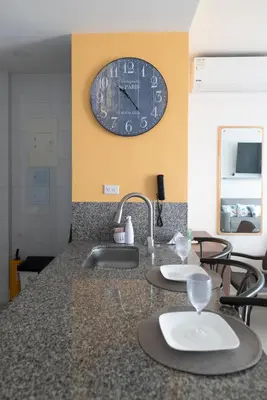 a kitchen with a sink and a clock on the wall at The Beaches-Beachfront Retreat in Cartagena de Indias