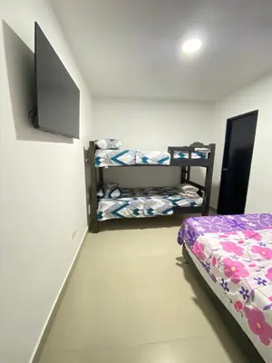 a bedroom with two bunk beds and a flat screen tv at Cómodo & Económico Apartamento para 4 pax en La Boquilla in Cartagena de Indias