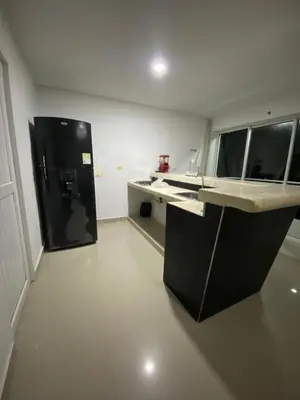 a kitchen with a black refrigerator in a room at Cómodo & Económico Apartamento para 4 pax en La Boquilla in Cartagena de Indias