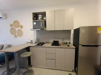 a kitchen with white cabinets and a stainless steel refrigerator at Apartamento Santa Marta Sector Don Jaca in Simón Bolivar