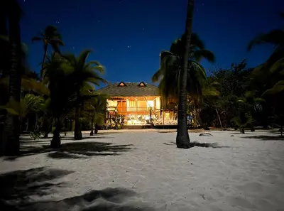 a house on the beach at night with palm trees at Beach House la Tortuga, Punta Seca, Rincón del Mar