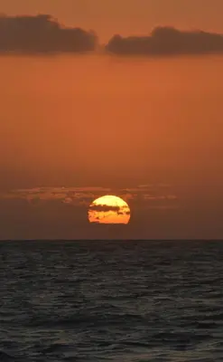 a sunset over the ocean with the sun in the sky at Beach House la Tortuga, Punta Seca, Rincón del Mar
