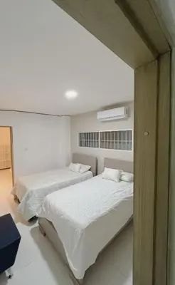 a bedroom with two beds and a air conditioner at New house in Barranquilla in Barranquilla