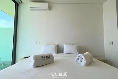 a bedroom with a bed with white sheets and pillows at Wai Blue/Luxury Beachfront/ Bello Horizonte/ TTO03 in Playa Dormida