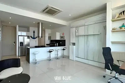 a kitchen with black chairs and a white floor at Wai Blue/Luxury Beachfront/ Bello Horizonte/ TTO03 in Playa Dormida