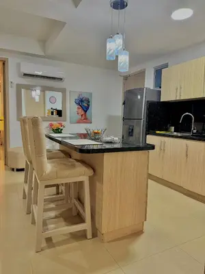 a kitchen with a counter with chairs and a microwave at Piso 30 vista al mar, Palmetto 1 Bocagrande in Cartagena de Indias