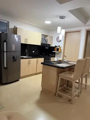 a kitchen with a refrigerator and a table and chairs at Piso 30 vista al mar, Palmetto 1 Bocagrande in Cartagena de Indias