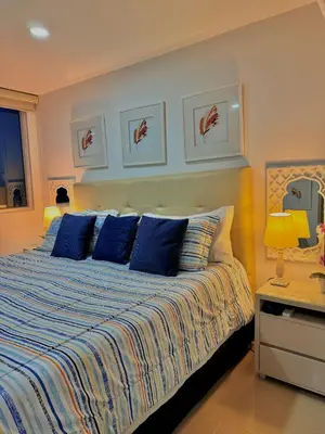 a bedroom with a large bed with blue pillows at Piso 30 vista al mar, Palmetto 1 Bocagrande in Cartagena de Indias