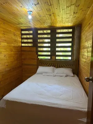 a bedroom with a bed in a wooden cabin at Ibiza beach in Moñitos
