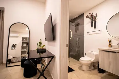 a bathroom with a toilet and a sink and a mirror at The Villa Catalina in Cartagena de Indias