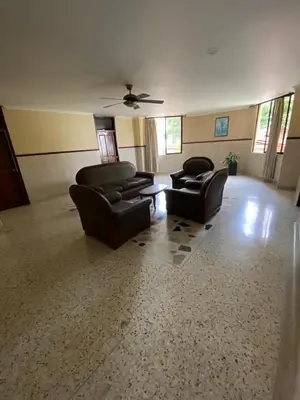 a living room with couches and a ceiling fan at Hotel San Francisco in Barranquilla