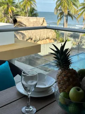 a table with a bowl of fruit and a wine glass at 302 Apartamento frente al mar in San Bernardo del Viento