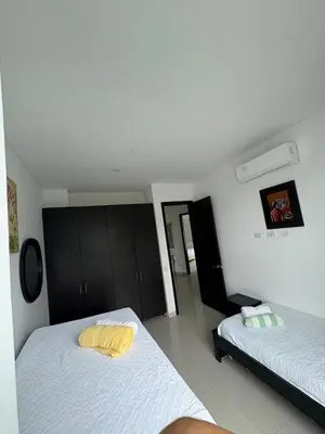 a bedroom with two beds with yellow pillows at Apartamento en Cartagena a pasos de la Playa in Cartagena de Indias