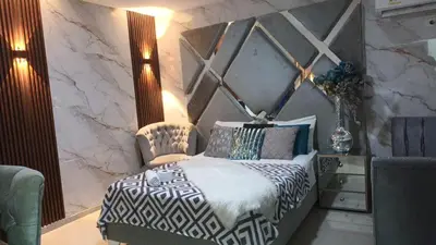 a bedroom with a black and white bed and a chair at Hotel Portolindo in Barranquilla