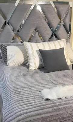 a bed with pillows and a cat laying on it at Hotel Portolindo in Barranquilla