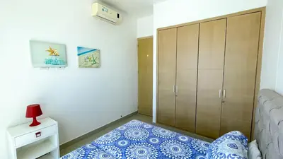 a bedroom with a bed and a large cabinet at Magico Apartamento Frente al Mar 4 Habitaciones BM33 in Coveñitas