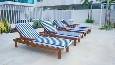 a row of wooden lounge chairs on a patio at Magico Apartamento Frente al Mar 4 Habitaciones BM33 in Coveñitas