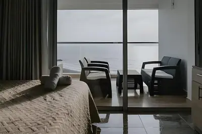 a bedroom with a bed and chairs and a table at Suite Frente al Mar en Cartagena 1410 in Cartagena de Indias